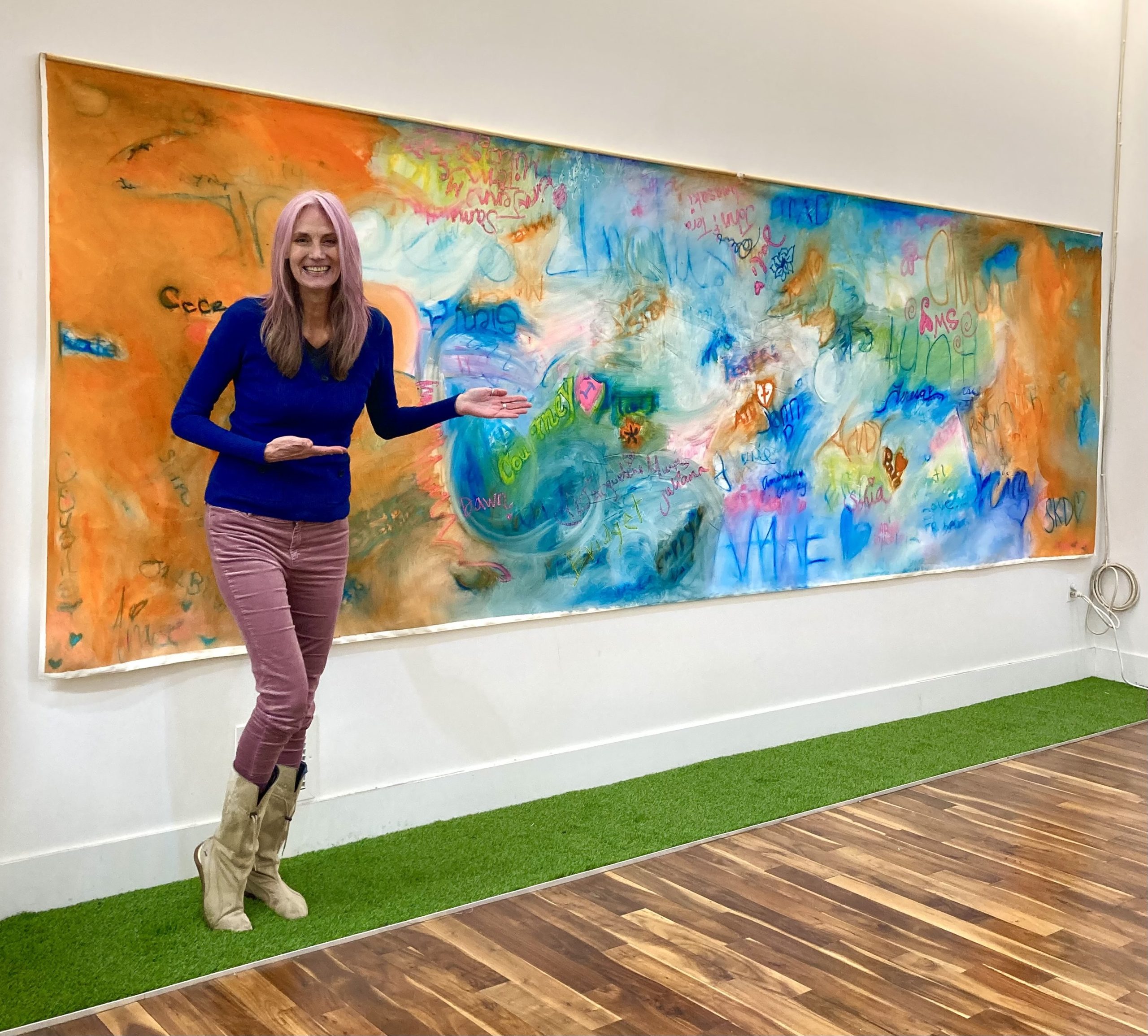 Marlyn in front of her collaborative orange painting